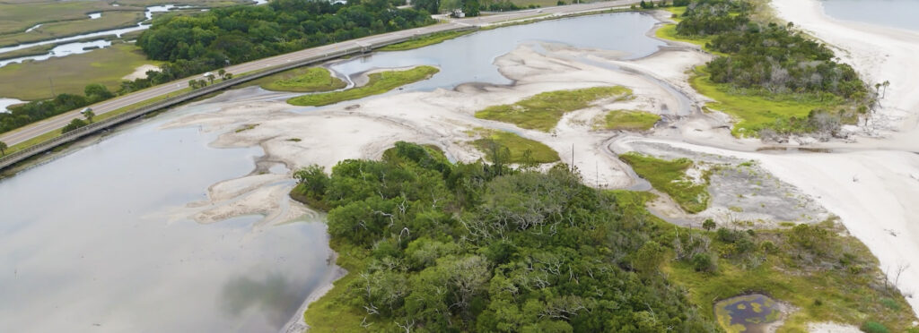 Wetlands with a road curving around it.